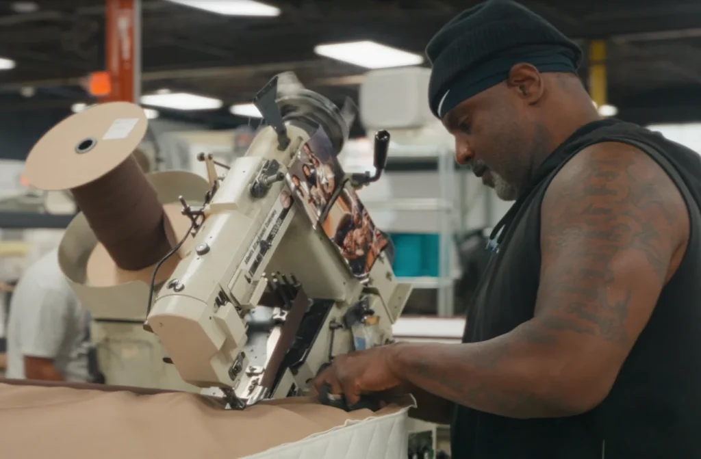 Worker building mattress in factory